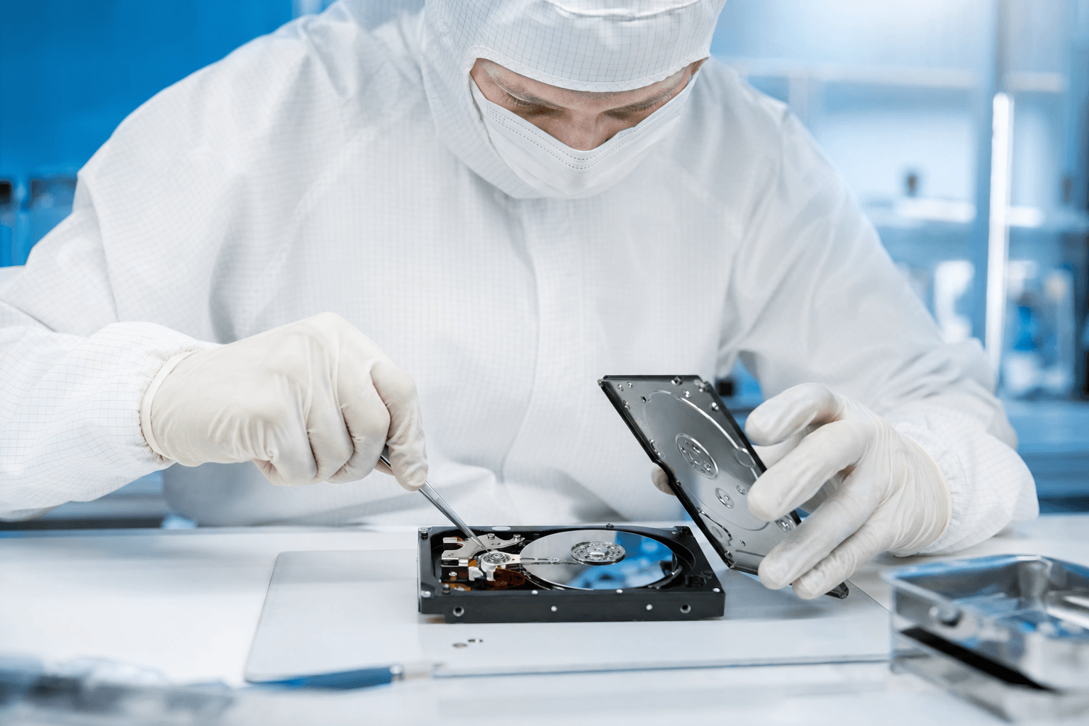 Technician performing head swap on hard drive in cleanroom